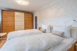 two beds in a hotel room with white sheets at Alpenaster 2 in Sonthofen