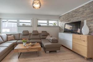 a living room with a couch and a tv at Alpenaster 2 in Sonthofen