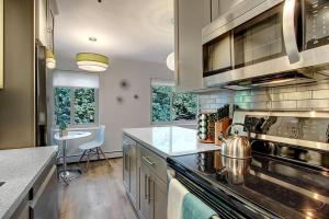 a kitchen with stainless steel appliances and a table at Modern Coastal Downtown, King bed, Work Desk, Kitchen in Seattle