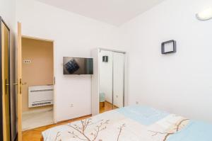 sypialnia z łóżkiem i telewizorem na ścianie w obiekcie Apartments 4M w Dubrowniku