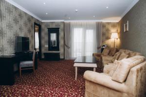 a living room with a couch and a piano at Colosseum Marina Hotel in Batumi