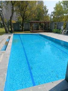 a large blue swimming pool in a yard at Sunahari Bagh - Pool Farm Retreat @ Gurgaon in Gurgaon