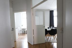 Habitación blanca con mesa y comedor en 2ndhomes Cozy and Quiet 2BR Apartment by the Esplanade Park, en Helsinki