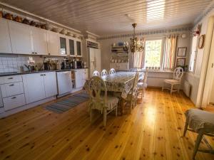 Villa Lövkulla with Sauna في Löparö: مطبخ وغرفة طعام مع طاولة وكراسي