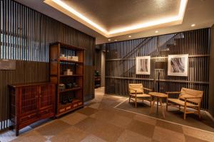 a lobby with chairs and a table and a shelf at Beppu Nagomitsuki in Beppu