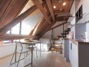 een keuken met een tafel en een trap in een kamer bij Escasa Ferienwohnungen in Heiligenberg