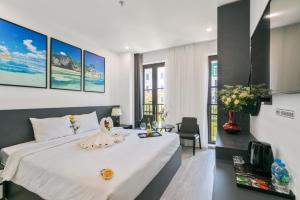 Un dormitorio con una gran cama blanca y un escritorio. en The Enchanted Ha Long Hotel, en Ha Long