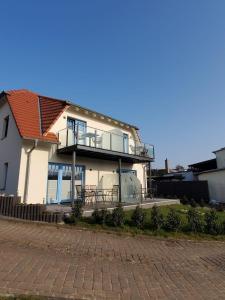 Casa blanca con porche y balcón en Ferienhaus am Yachthafen en Sellin