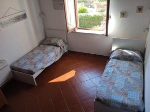 ポルトフェッラーイオにあるIl Mulino Di S. Giovanniのベッド2台と窓が備わる客室です。