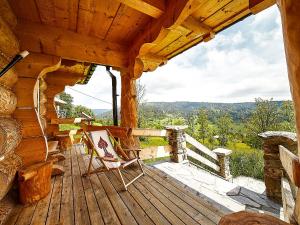 ObidowaにあるJarogówka Stylowy dom góralskiの小屋の木製のポーチにロッキングチェア