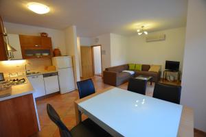 a kitchen and a living room with a table and chairs at Apartment Silva in Kornić