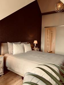 een slaapkamer met een groot bed met een zwart hoofdeinde bij B&B Marie-J of Bruges in Brugge