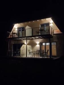 a building with a deck with tables and chairs at night at Ferienhaus am Yachthafen in Sellin