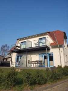 a large white house with a table and chairs at Ferienhaus am Yachthafen in Sellin