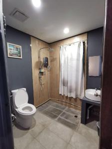 a bathroom with a toilet and a shower and a sink at Ang Lee Holiday Stay in Semporna