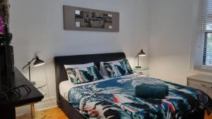 ein Schlafzimmer mit einem Bett mit einer Bettdecke und Kissen in der Unterkunft The Atrium - A Stylish Home with up to 6 Bedrooms in Port Pirie