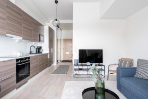 Il comprend un salon avec un canapé bleu et une cuisine. dans l'établissement 2ndhomes Tampere "Kaplan #3" Brand New Apartment - Modern & Cozy, à Tampere