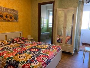 - une chambre avec un lit doté d'un couvre-lit coloré dans l'établissement B&B CATANIA CENTRO - Charme & More, à Catane
