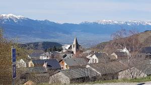 a small town with a church and snowy mountains at LES FONTANILLES odeillo chalet 60 WIFI & PARKING gratuit exposé plein sud & plein pied , draps & serviettes de toilettes non inclus, sabanas y toallas no incluidos in Font-Romeu-Odeillo-Via