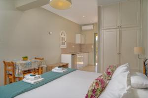 a bedroom with a large white bed and a kitchen at Porto Giardino Apartments in Kypseli