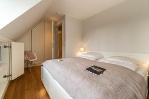 ein Schlafzimmer mit einem Bett, auf dem ein Buch liegt in der Unterkunft Kapitänshaus West in Oldsum