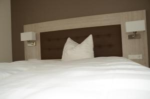 a large white bed with two pillows on it at Pension die kleine Träumerei in Griesheim