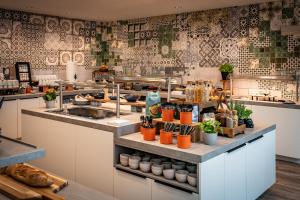 a kitchen with a counter with plants on it at LOGINN Hotel Stuttgart Zuffenhausen in Korntal-Münchingen