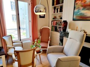 a living room with chairs and bookshelves at Face à l'hôtel de ville grand et lumineux appartement in Angoulême