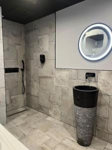 a bathroom with a shower and a trash can at Chambre privatif spa in Lestrem
