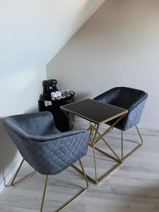 two blue chairs and a table in a room at Chambre privatif spa in Lestrem