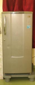 einen Metallkühlschrank in einem Zimmer mit roter Wand in der Unterkunft PINE VILLA GARDEN in Yercaud