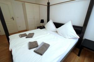 エッセンにあるAparthotel Kompass A 204の白いベッド(タオル2枚付)
