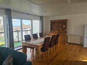 uma sala de jantar com uma mesa de madeira e cadeiras em Tamar 16 em Gunnislake