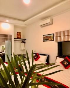 ein Schlafzimmer mit 2 Betten und einer Pflanze in der Unterkunft Sunny Garden Homestay in Hoi An