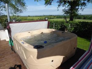 a large hot tub sitting on a deck at Private Gite with heated pool with retractable cover and hot tub in Cendrieux
