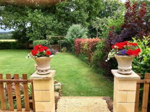 a garden with two vases with flowers on a fence at Private Gite with heated pool with retractable cover and hot tub in Cendrieux