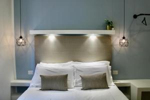 a bedroom with a white bed with two pillows at Kerasiá in Florence