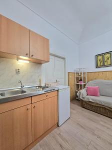 a kitchen with a sink and a couch in a room at Studio Heart of the Town in Dubrovnik