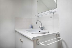 Un baño blanco con lavabo y espejo. en Grande Brévinoise dans les pins, en Saint-Brevin-les-Pins 28 fotos más