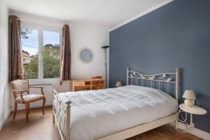 Un dormitorio con una cama, una silla y una ventana en Grande Brévinoise dans les pins, en Saint-Brevin-les-Pins