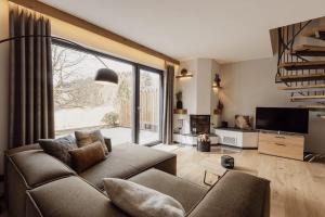 a living room with a couch and a large window at Asten-Chalets in Winterberg