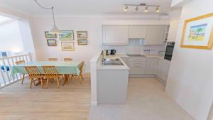 a kitchen and dining room with a table and chairs at Clifton Court Apt 16 with Indoor Heated Pool & Sea Views in Croyde