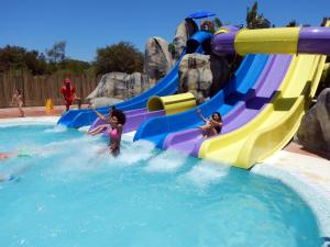 a group of children playing on a water slide at a water park at Ohtels Mazagon in Mazagón
