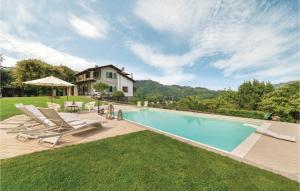 a swimming pool with chairs and a house at Amazing Home In Camaiore lu With Wifi in Camaiore