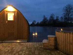 eine Leguan-Hütte aus Holz mit einem Pool in der Nacht in der Unterkunft Ferienwohnungen Gut Oestergaard in Steinberg