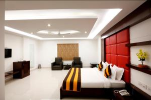 a hotel room with a bed and two chairs at Hotel Anand International in New Delhi