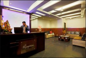 a man talking on a cell phone in a lobby at Hotel Anand International in New Delhi