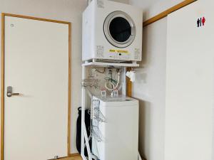 un microondas sentado en la parte superior de una nevera junto a una puerta en Backpackers Hostel TSUBAMENOYADO, en Shizuoka 37 fotos más
