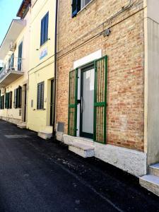 a brick building with a green door on a street at Casa Vacanze Po in Vasto