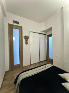 a bedroom with a large bed and two windows at Oasis city apARTment in Heraklio